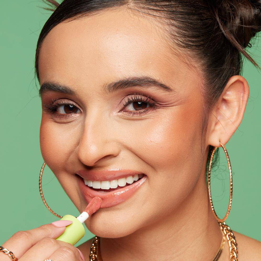 Close-up of a model’s face as she applies NYX Fat Oil Lip Drip, showcasing how to keep lips moisturised