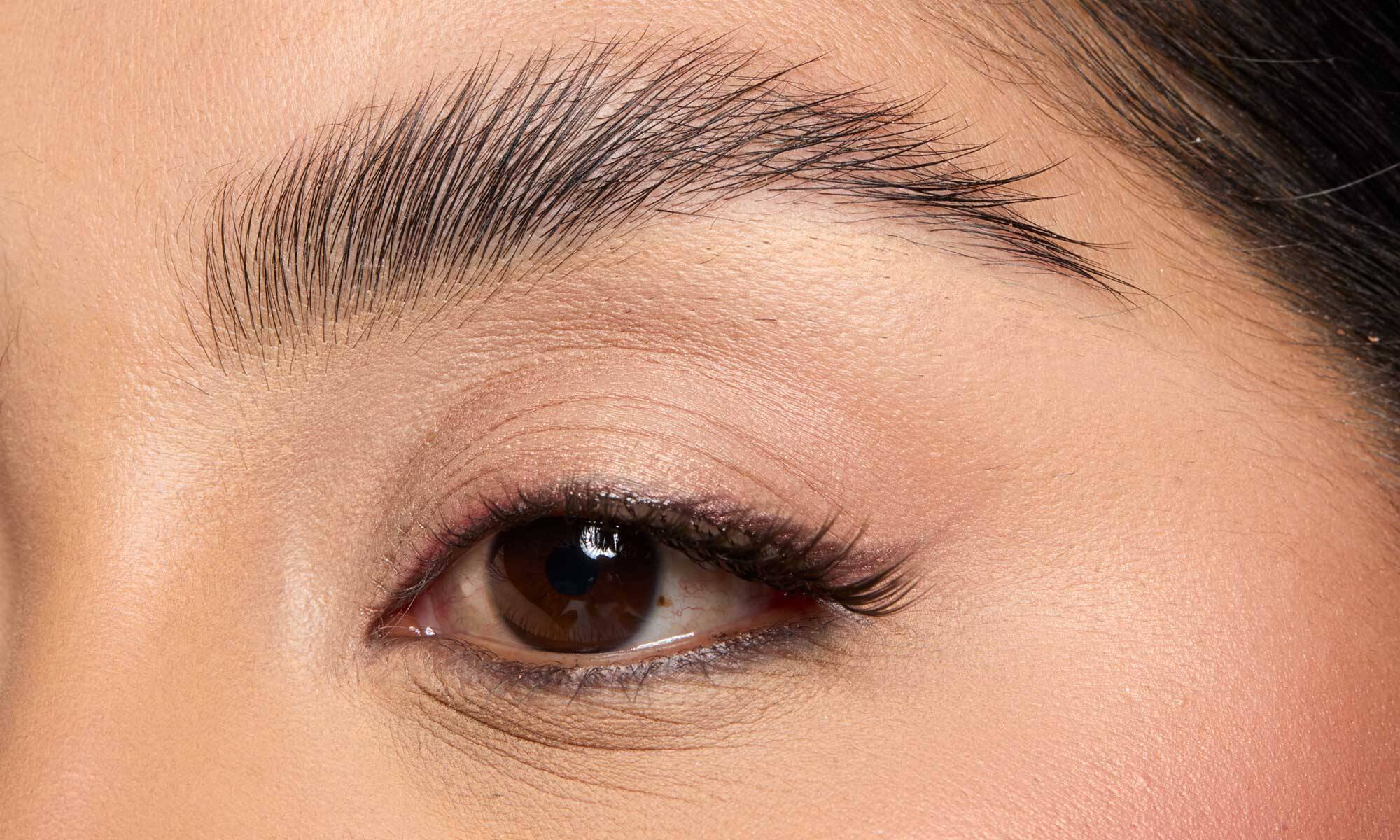 A woman after shaping her eyebrows at home