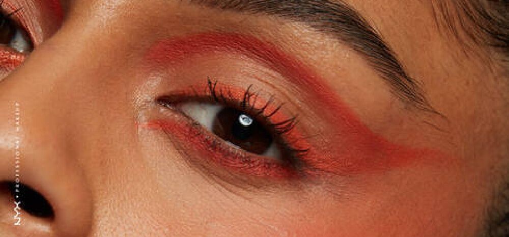 A woman applying a bold eye makeup