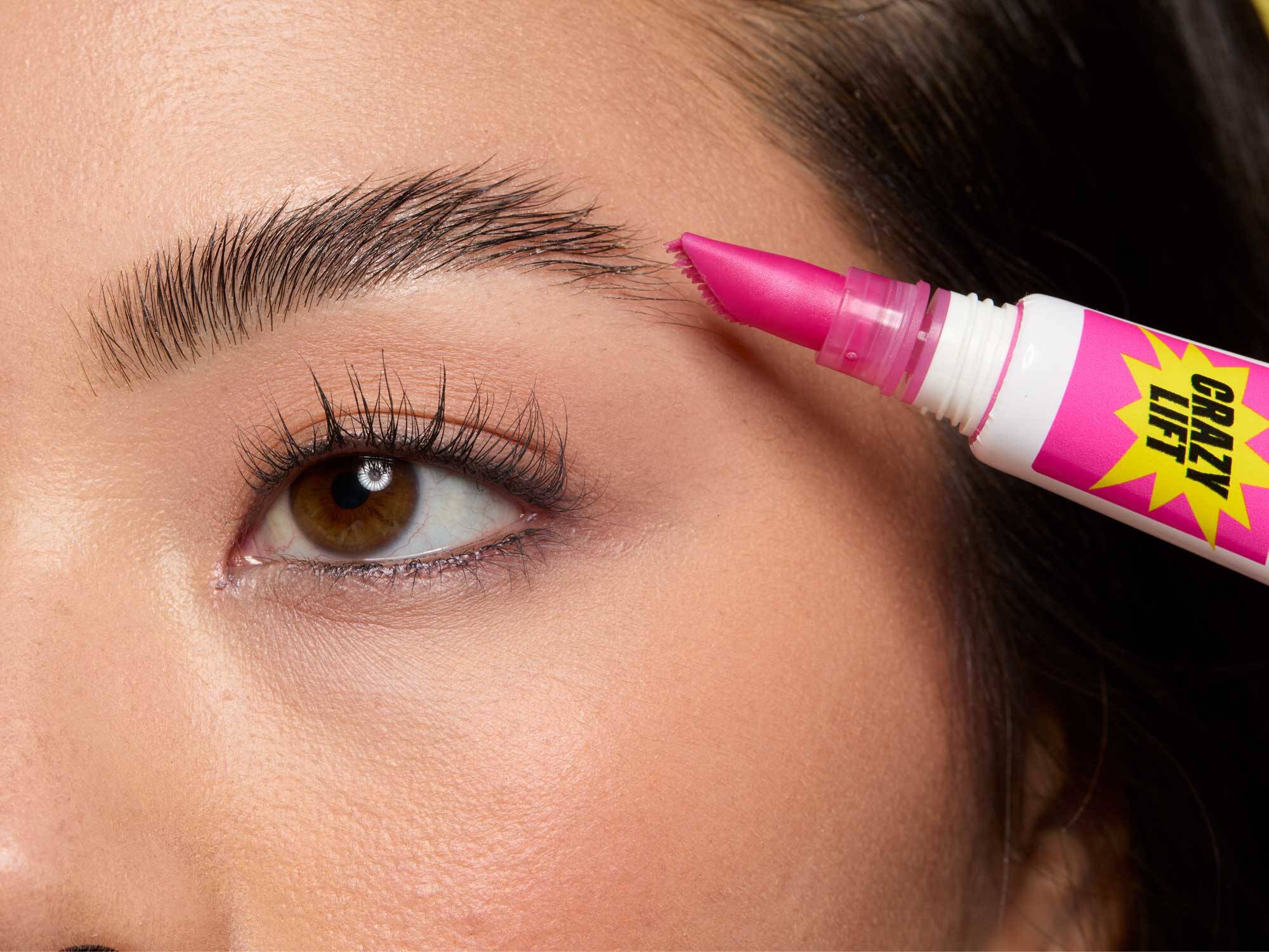 Close-up of a woman shaping her eyebrows at home using the Brow Glue Crazy Lift Lamination Brow Gel, demonstrating how to shape eyebrows for beginners and different face shapes.