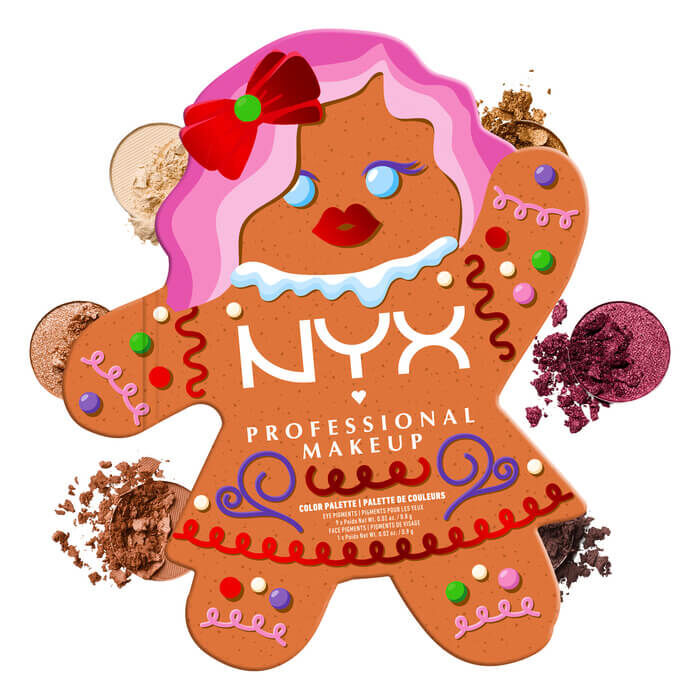 Shows the NYX Professional Makeup Holiday Gingerbaddie Palette closed, surrounded by scattered loose eyeshadow pigments that are shade from the palette.